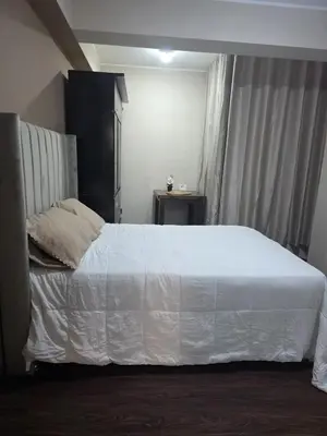 a bedroom with a large bed with white sheets at room rent in Lima