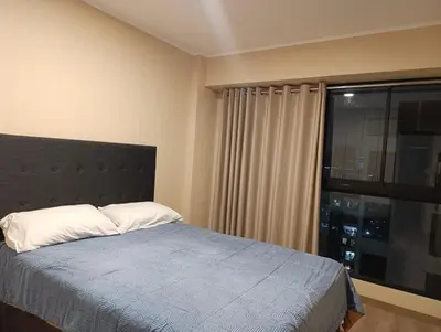 a bedroom with a bed and a large window at Amplio Dpto Centrico frente al Hospital Rebagliati in Lima