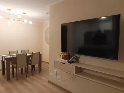 a dining room with a large television on a wall at Amplio Dpto Centrico frente al Hospital Rebagliati in Lima