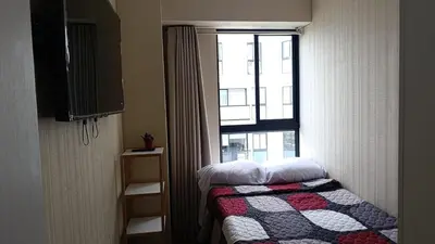 a small bedroom with a bed and a window at Amplio Dpto Centrico frente al Hospital Rebagliati in Lima