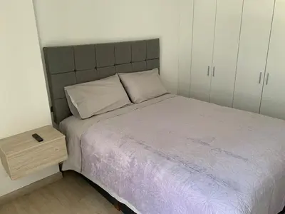 a small bedroom with a bed and a night stand at Modern apartment in Larco 791 in Lima