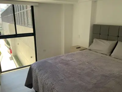 a bedroom with a bed and a large window at Modern apartment in Larco 791 in Lima