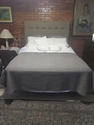 a large bed with white pillows in a bedroom at Nice country house with a swimming pool and large garden in Cieneguilla
