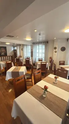a restaurant with tables and chairs with white tablecloths at Xima Cusco Kenamari in Cusco