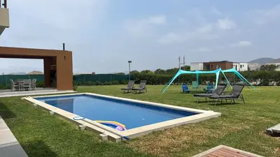 a swimming pool with chairs and a slide in a yard at House 3M in Condominium Fundo Pradera, Chocaya - Lima - Perú in Asia