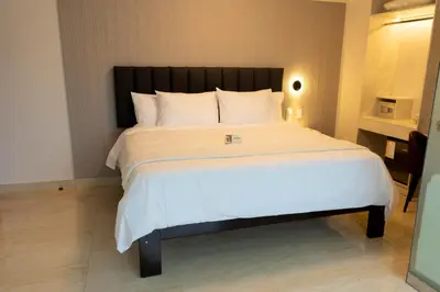 a bedroom with a large bed with white sheets at Solay Inn in Ayacucho