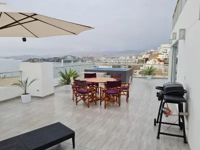 a patio with a table and chairs and an umbrella at Duplex - Playa Embajadores in Quebrada Seca