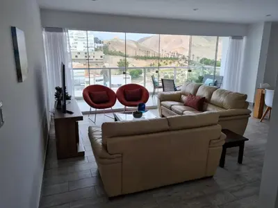 a living room with a couch and two red chairs at Duplex - Playa Embajadores in Quebrada Seca