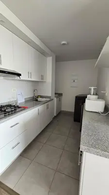 a kitchen with white cabinets and a counter top at Departamento exclusivo en San Bartolo in San Bartolo