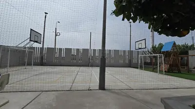 a tennis court with a net and basketball hoop at Departamento exclusivo en San Bartolo in San Bartolo