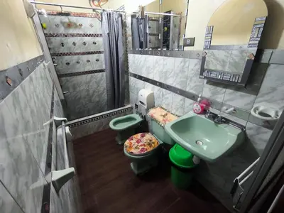 a small bathroom with a sink and two toilets at Victoria home in Cusco