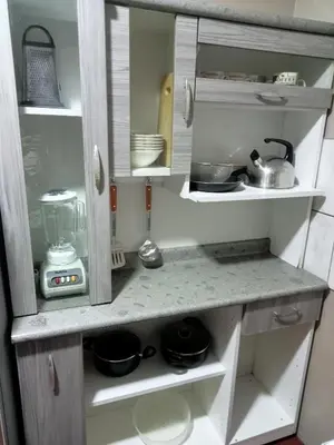 a kitchen cabinet filled with pots and pans at Departamento 2 dormitorios 4B in Lima