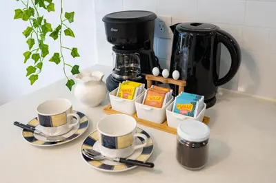 a counter with cups and plates and a coffee maker at All San Isidro Apartments by Vibrant in Lima