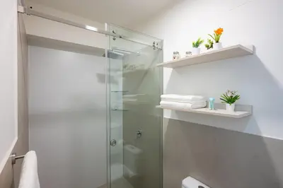 a bathroom with a shower with a glass door at All San Isidro Apartments by Vibrant in Lima