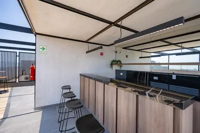 a kitchen with stools and a bar in a building at All San Isidro Apartments by Vibrant in Lima