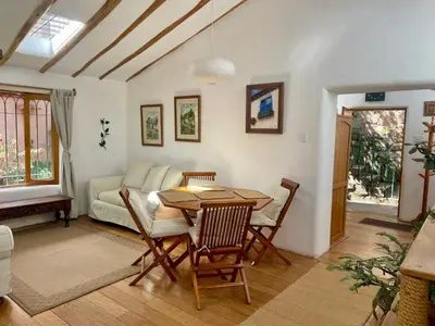 a living room with a table and a couch at Kusi Qente in Cusco