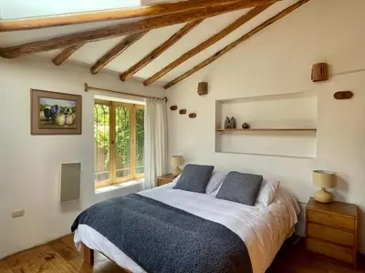 a bedroom with a large bed and a window at Kusi Qente in Cusco