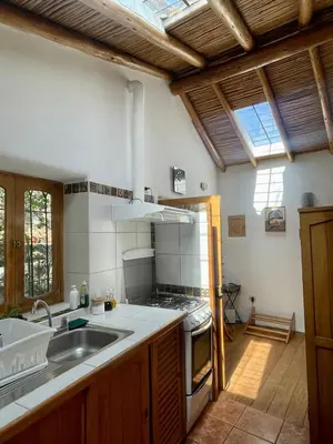 a kitchen with a sink and a stove top oven at Kusi Qente in Cusco