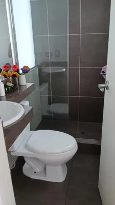 a bathroom with a toilet and a glass shower at Habitación in Lima