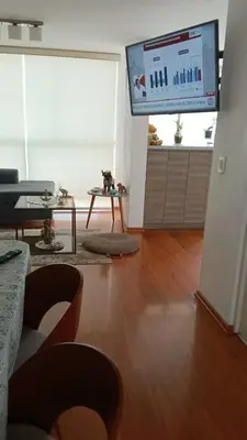 a living room with a flat screen tv and a table at Habitación in Lima