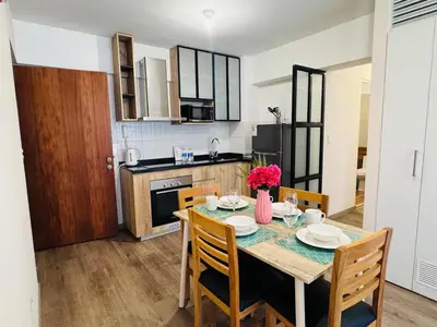 a kitchen with a dining room table with chairs and a table at M15 - Two Bedroom Apartment in front of the US Embassy in Lima
