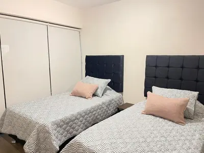 a bedroom with two beds with pink pillows at M24 Departamento de 2 Dorm 2 baños - Frente Embajada de USA in Lima
