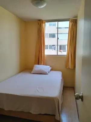 a small bedroom with a bed with a window at Welcome to this apartment Pet friendly in Lima