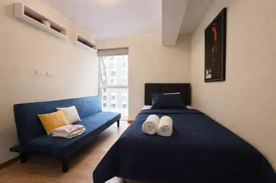 a bedroom with a blue bed and a blue couch at Amplio depa 3 habitaciones en Costanera in Lima