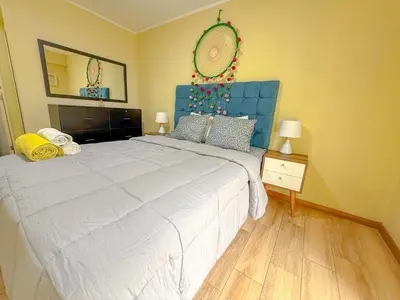 a bedroom with a large bed with a blue headboard at Amplio depa 3 habitaciones en Costanera in Lima