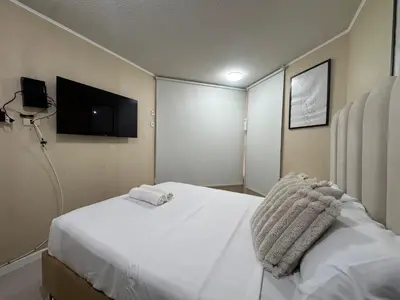a hotel room with a bed and a flat screen tv at Flat 1BR San Miguel cerca a Malecón con balcón in Lima