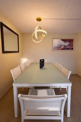 a dining room with a white table and a chandelier at Departamento Cerca al Aeropuerto Jorge Chavez in Lima