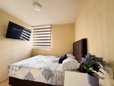 a bedroom with a bed and a window at Departamento Cerca al Aeropuerto Jorge Chavez in Lima