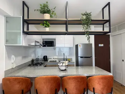 a kitchen with a counter with chairs and a refrigerator at Departamento 2BR Santa Beatriz cerca al Circuito Mágico del Agua Céntrico in Lima