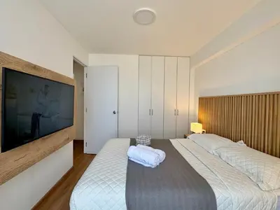 a bedroom with two beds and a flat screen tv at Departamento 2BR Santa Beatriz cerca al Circuito Mágico del Agua Céntrico in Lima