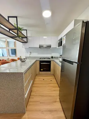 a kitchen with white cabinets and a black refrigerator at Departamento 2BR Santa Beatriz cerca al Circuito Mágico del Agua Céntrico in Lima