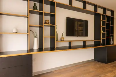 a living room with wooden shelves and a television at Moderno apartamento en San Isidro in Lima
