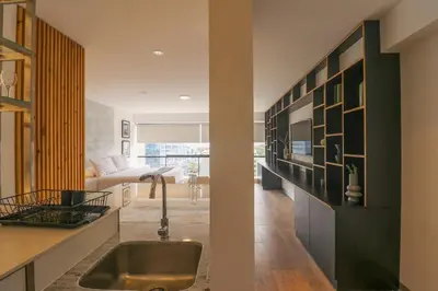 a kitchen with a sink and a living room at Moderno apartamento en San Isidro in Lima