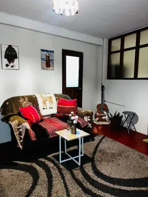 a living room with a couch and a table at AndeanNook-Cusco in Cusco