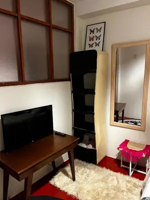 a living room with a table and a tv and a mirror at AndeanNook-Cusco in Cusco