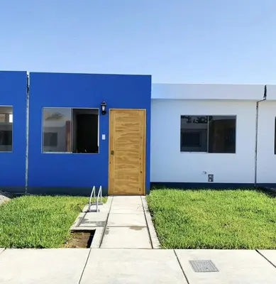 a blue building with a wooden door and grass at Encantadora casa en Menorca - Ica in Ica