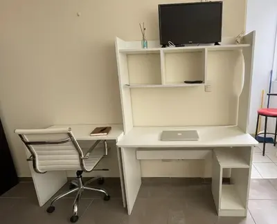 a white desk with a computer and a chair at A cozy apartment in the heart of Miraflores in Lima