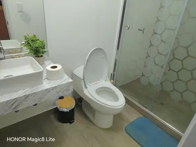 a bathroom with a toilet and a shower and a sink at Departamento The Lead 509 con Piscina in Lima