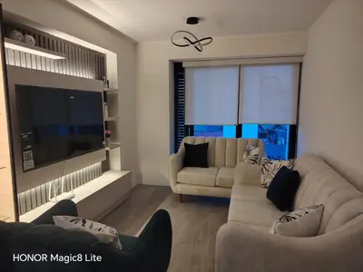 a living room with two couches and a large window at Departamento The Lead 509 con Piscina in Lima