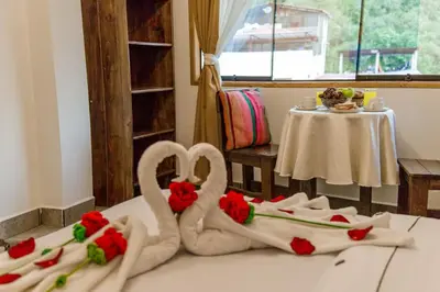 two towels shaped like swans sitting on a bed at Hotel MachuPicchu Humantay in Machu Picchu