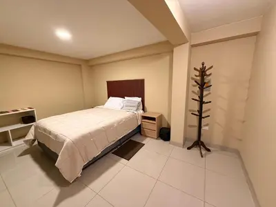 a bedroom with a bed and a tree in it at Tres Cruces Private Rooms in Cusco