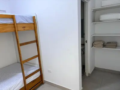 a room with two bunk beds and a closet at Casa de playa en Cerro Azul con piscina privada in Cerro Azul