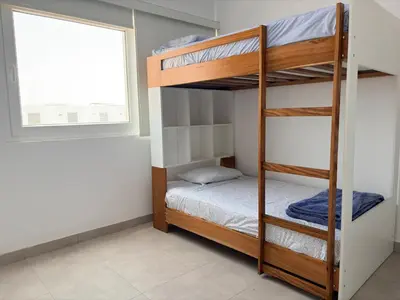 a bedroom with bunk beds and a window at Casa de playa en Cerro Azul con piscina privada in Cerro Azul