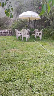 two chairs and an umbrella in a yard at Casa Portada del Sol La Molina in Lima