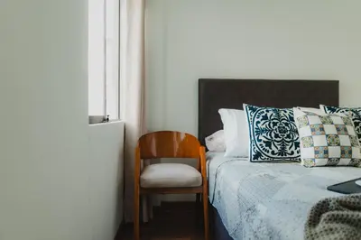 a bedroom with a bed and a chair next to a window at Recavarren 3 Dormitorios by Casa Miraflores - Wifi - Washer - Hot Water in Lima