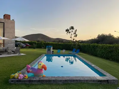 a swimming pool with a toy in the grass at Casa de Campo Azpitia Perú in Santa Cruz de Flores